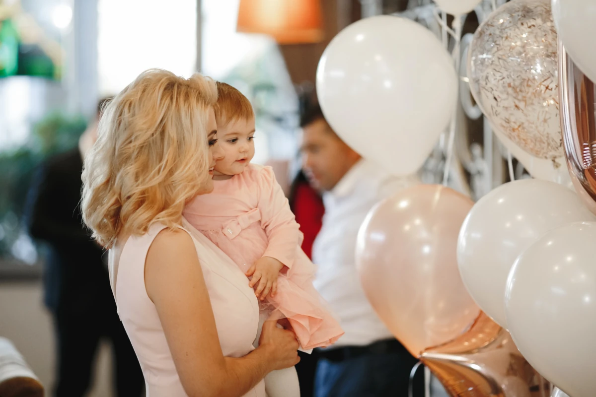 Praznovanje otroka, ki ga mama drži v naročju